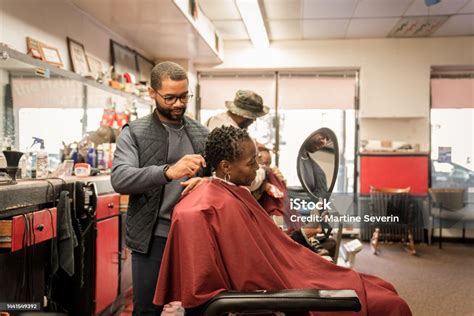 Black Customers Receive A Haircut From Barbers At A Black Owned