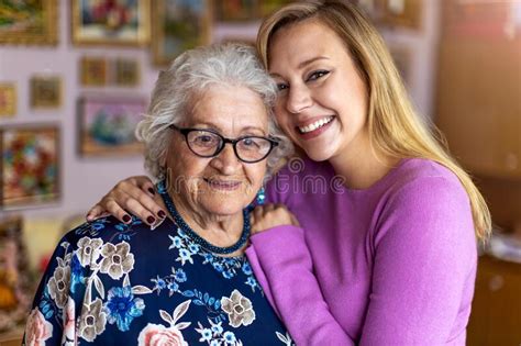 Young Woman Spending Time With Her Elderly Grandmother At Home Stock