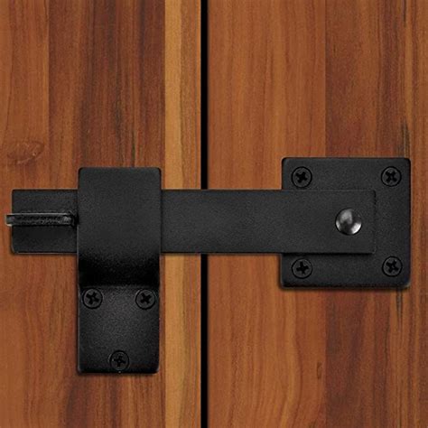 A Close Up Of A Door Handle On A Wooden Door With Black Metal Latches