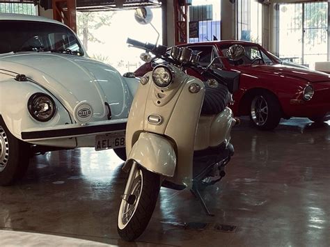 Two Cars And A Motorcycle In A Garage