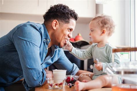 Un Padre Y Un Peque O Hijo Del Ni O Que Comen La Fruta Y El Yogur