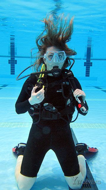 A Woman In A Diving Suit Is Holding A Snorkel And Posing For The Camera