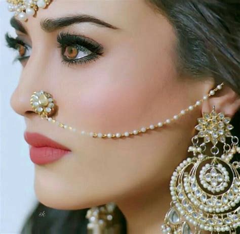 A Close Up Of A Woman With Jewelry On Her Face And Nose Piercings In The Shape Of Circles