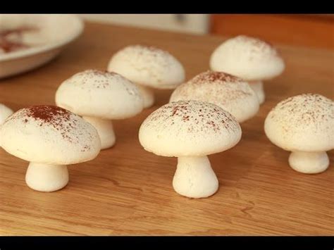 Small White Mushrooms Sitting On Top Of A Wooden Table