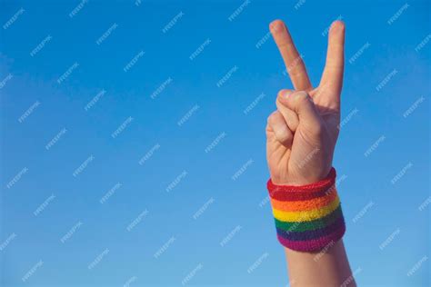 Premium Photo Gay Pride Concept Hand Making A V Peace Sign With Gay Pride Lgbt Rainbow Flag