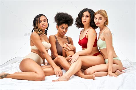 Sexy And Multiethnic Women In Colorful Lingerie Looking At Camera While