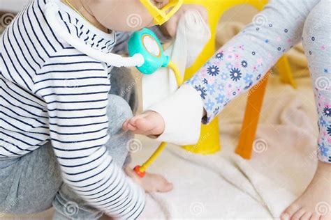 Two Children Play Doctor In The Nursery Brother In Yellow Glasses