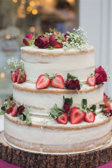 A Three Tiered Cake With Strawberries On Top