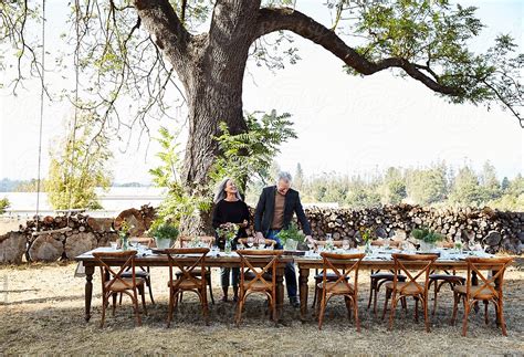 Senior Couple Setting The Table For A Farm To Table Dinner Party At