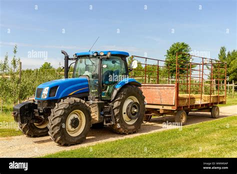 Agricultural Machinery On The Field Moves Bales Of Hay After Harvesting