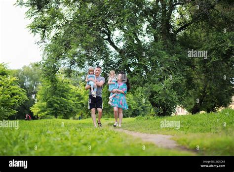 Mom With Two Daughters Twins For A Walk In The Park Stock Photo Alamy