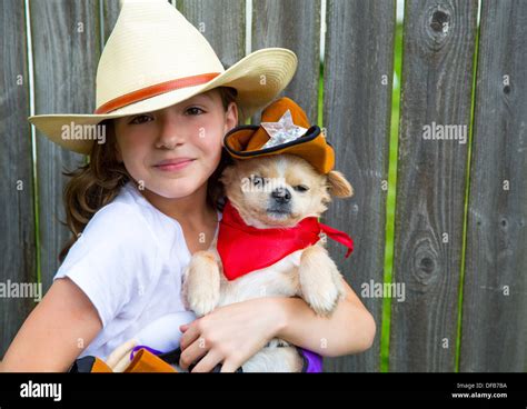 Beautiful cowboy kid girl holding chihuahua dog with sheriff hat in ...