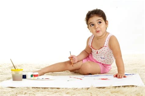 Linda Garota Desenhando Tintas Em Um Papel Sobre Um Fundo Branco Foto