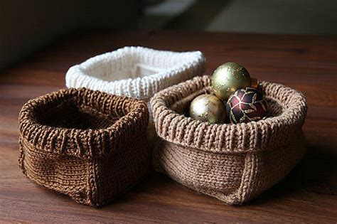 Two Knitted Baskets Sitting On Top Of A Wooden Table Next To Each Other