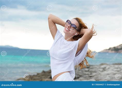 Smiling Young Woman Enjoying Her Summer Vacation On The Beach