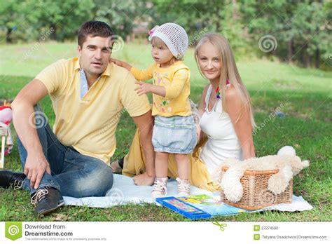 Familia Feliz Que Tiene Comida Campestre En Parque Foto De Archivo