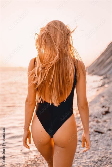 Blonde Attractive Woman In Black Bikini Relaxed On Beach With Warm Sunset Colors Foto De Stock