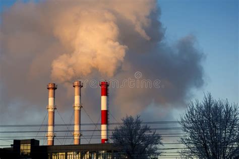 Rook Van Industriële Schoorsteen Tegen Een Blauwe Hemel Stock