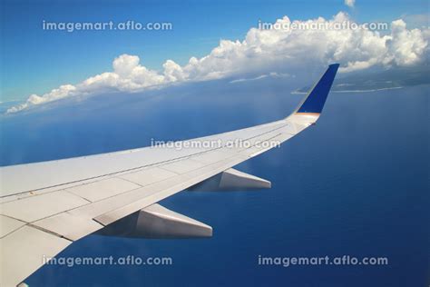 飛行機の窓から見た飛行機の翼と青空と白い雲｜風景写真 168234528 イメージマート