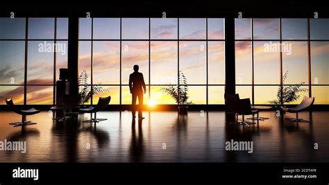 Business Man Standing In The Office Looking Out Of The Window At Sunset