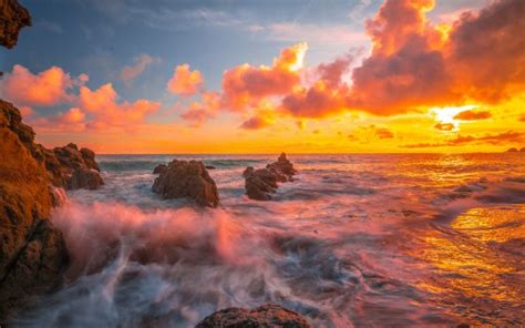 Rock Stones On Ocean Waves Under White Yellow Clouds Sky During Sunset