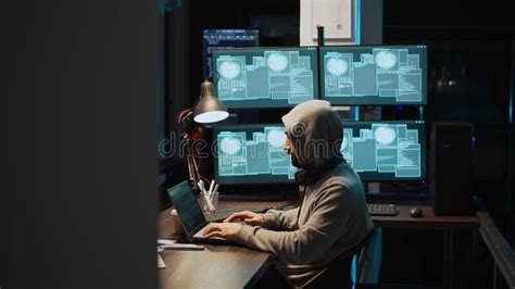 Masked Cyber Thief Hacking Computer Network At Night Stock Photo