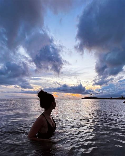 Девушка в океане на рассвете на Бали Bali Celestial Bodies Sunset