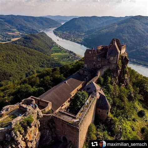 an aerial view of a castle in the middle of a mountain range with water ...