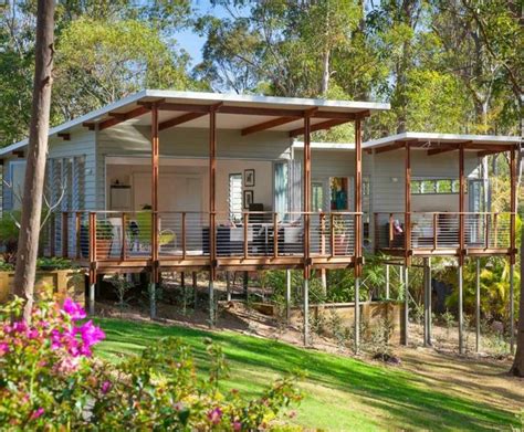 Two Cabins In The Woods With Decking And Balconies On Each Side