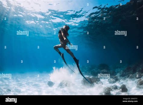 Woman Freediver Glides With Sand Over Sandy Bottom Freediving