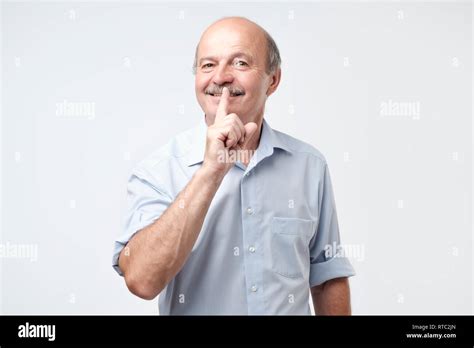Mature Bald Man With Finger On Lips Asking For Silence Top Secret