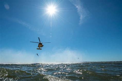 A U.S. Coast Guard rescue swimmer ascends into a helicopter - PICRYL Public Domain Search