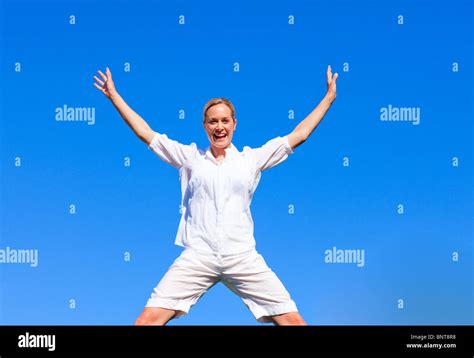 Happy Woman Jumping Against Blue Sky Stock Photo Alamy