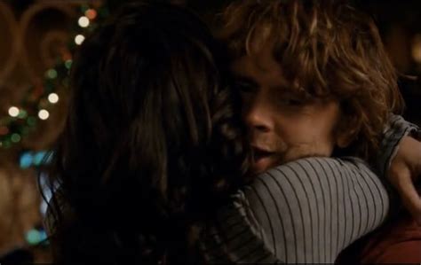 a young man and woman embracing each other in front of a christmas tree ...