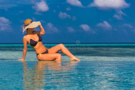 Woman In Bikini In The Pool Watching The Sea Background In Maldives