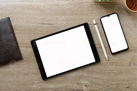 Black tablet with white blank screen is on top of brown paper with ...