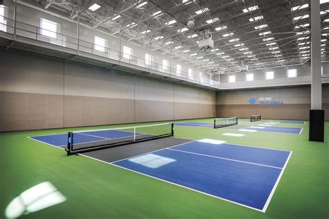 An Indoor Tennis Court With Blue And Green Courts