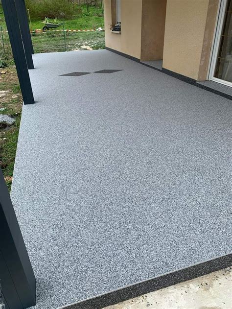 An Outdoor Patio With Grey Concrete And Black Trim