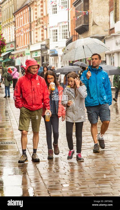 People Walking And Shopping In The Rain Under Umbrellas In The High