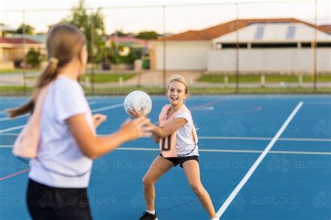 Image Of Two Children Playing Netball On Outside Netball Court