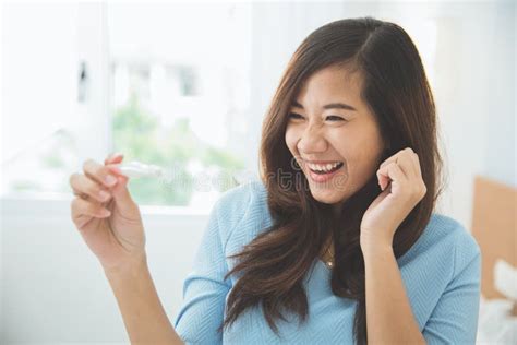 Asian Young Woman With A Testpack In Her Hand Smiling Happily Stock