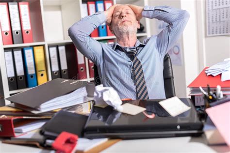 Overworked Businessman Sitting At A Messy Desk Stock Photo Image Of