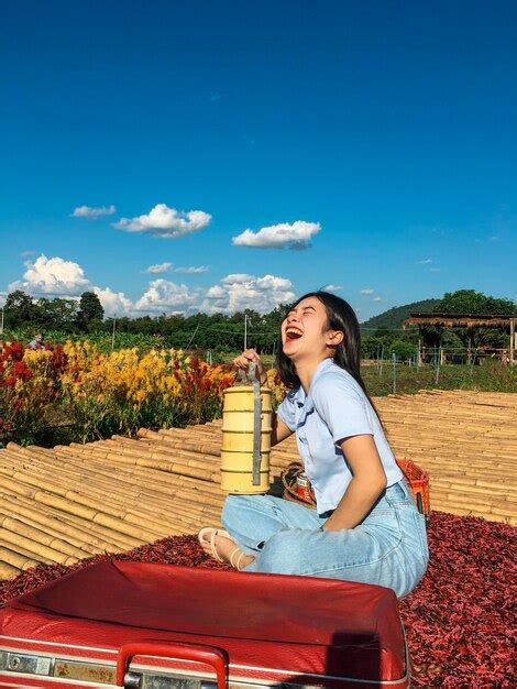 Vista Lateral De Una Joven Sonriente Sentada En Un Asiento En El Campo