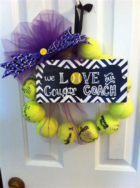 A Door Hanger With Tennis Balls And Purple Tulle On It That Says We