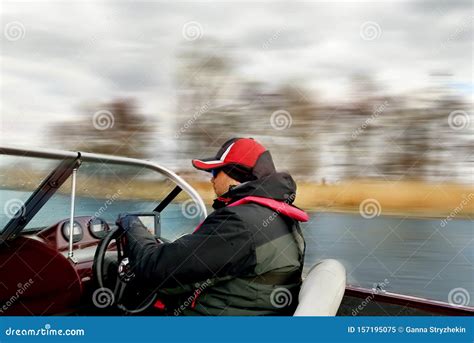 A Man Driving A Boat At High Speed Rushes Along The River Smeared From