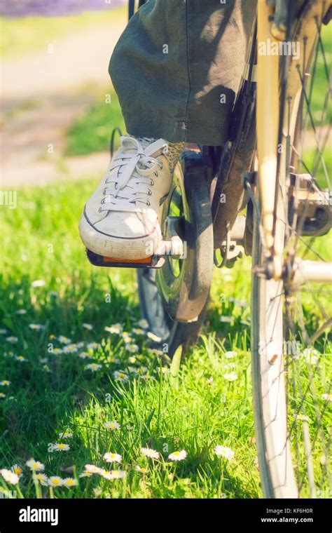 White Sneakers On Womans Legs On A Bike During Sunny Summer Day In A