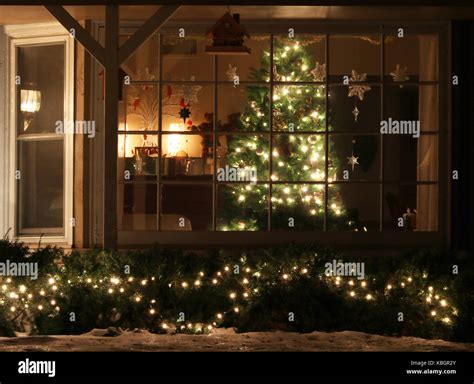 Window With Decorated Glowing Christmas Tree Inside A House And Stock