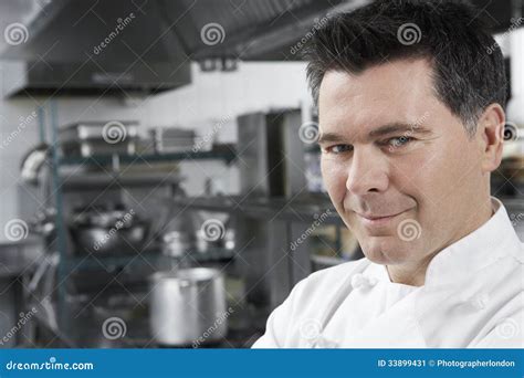 Glimlachende Mannelijke Chef Kok In Kitchen Stock Afbeelding Image Of