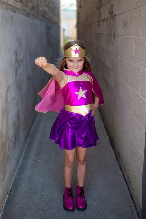 young girl playing dress up as superhero