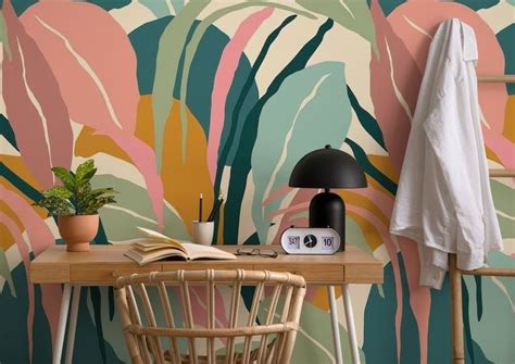 A Desk With A Lamp Book And Plant On It Next To A Wallpaper